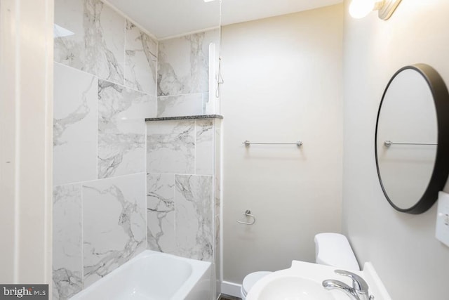 full bathroom featuring tiled shower / bath, toilet, and sink