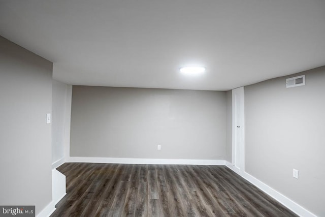 basement with dark hardwood / wood-style floors