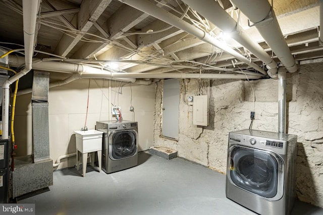 basement with washing machine and dryer, sink, and electric panel