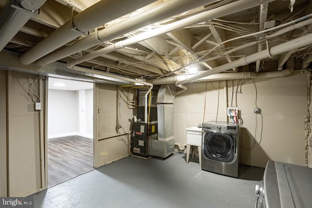 basement featuring heating unit and washer / dryer