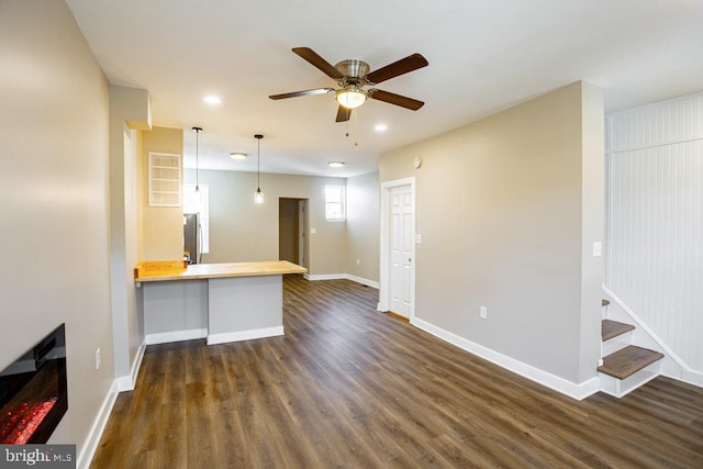 unfurnished living room with dark wood-type flooring and ceiling fan