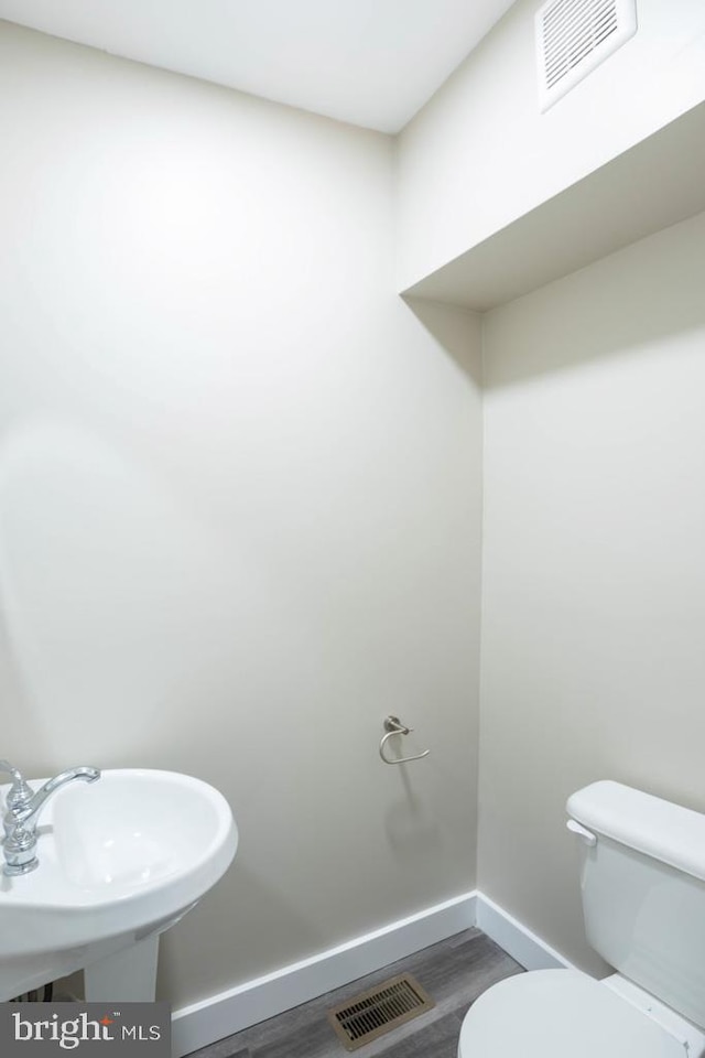 bathroom with hardwood / wood-style flooring, sink, and toilet