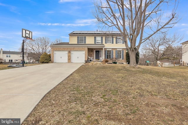 view of front of home featuring a garage, a front yard, and solar panels