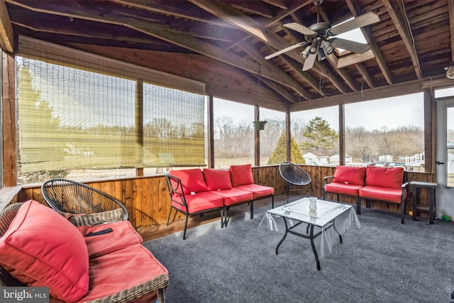 sunroom / solarium with ceiling fan and vaulted ceiling with skylight