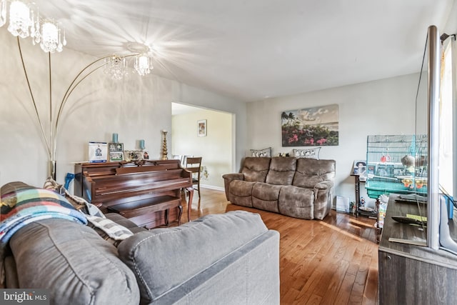 living room with hardwood / wood-style flooring and an inviting chandelier