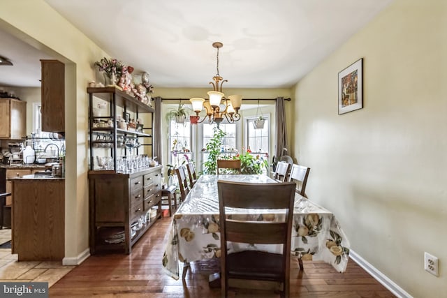 dining room with dark wood-type flooring and a notable chandelier