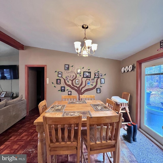 dining area with a notable chandelier and dark parquet flooring