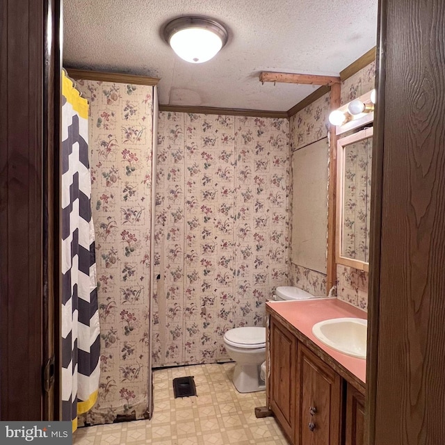 bathroom featuring vanity, ornamental molding, toilet, and a textured ceiling