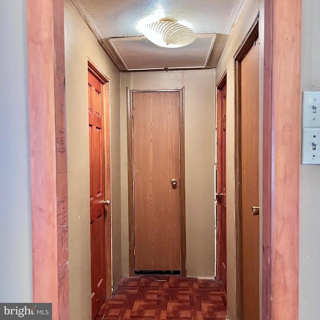 hallway with dark parquet flooring and a textured ceiling