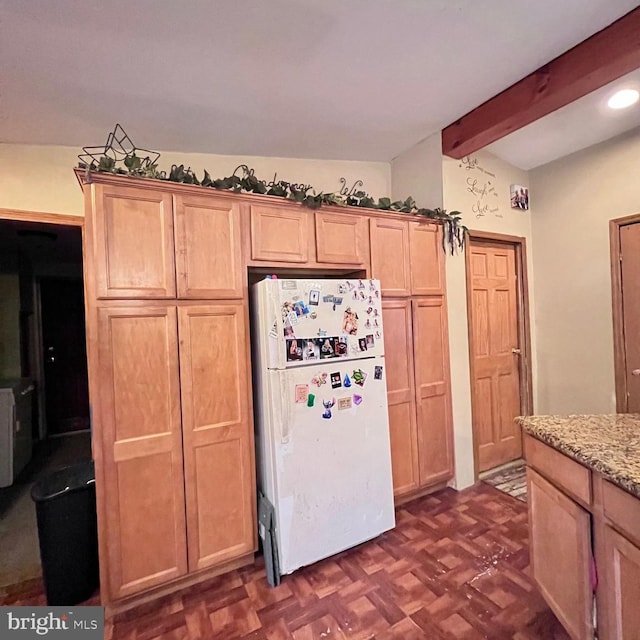 kitchen featuring dark parquet flooring, light stone counters, light brown cabinets, white refrigerator, and beam ceiling