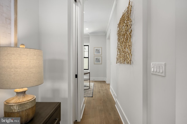 hallway featuring hardwood / wood-style flooring and ornamental molding