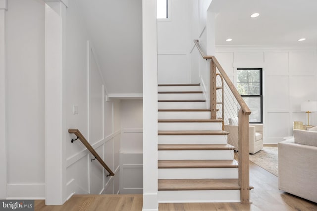 staircase featuring hardwood / wood-style flooring and ornamental molding