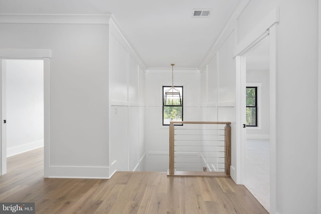 spare room featuring ornamental molding and light wood-type flooring