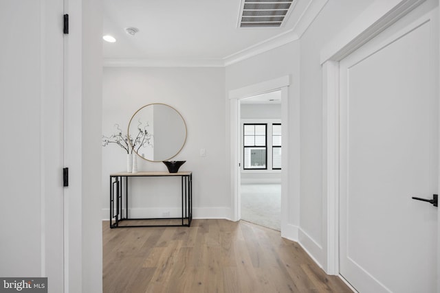 corridor featuring crown molding and light hardwood / wood-style flooring