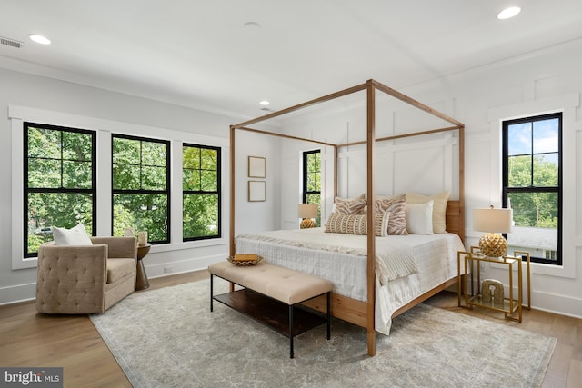 bedroom featuring multiple windows and light hardwood / wood-style flooring