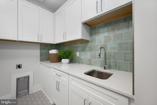 kitchen with white cabinetry, sink, and decorative backsplash