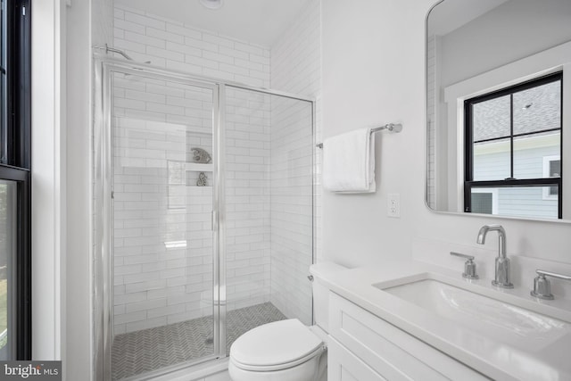 bathroom with vanity, a shower with shower door, and toilet