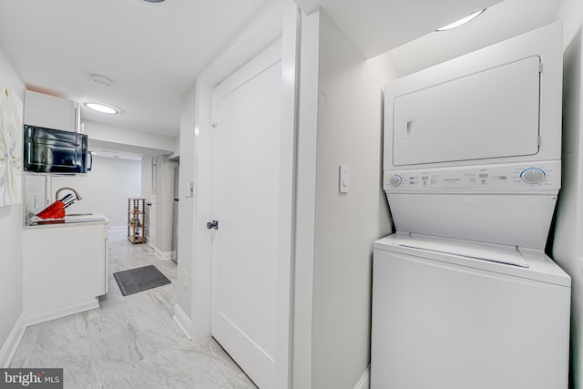 laundry room with stacked washer / drying machine and sink