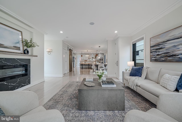 living room featuring crown molding, a high end fireplace, and hardwood / wood-style floors