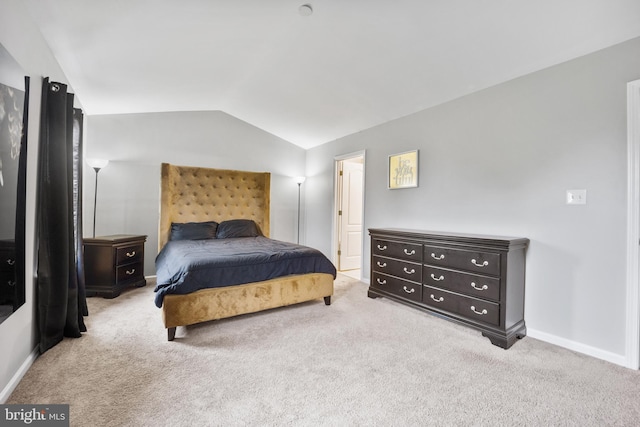 bedroom featuring vaulted ceiling, light carpet, and baseboards