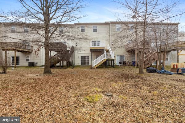 rear view of property with central AC and stairway