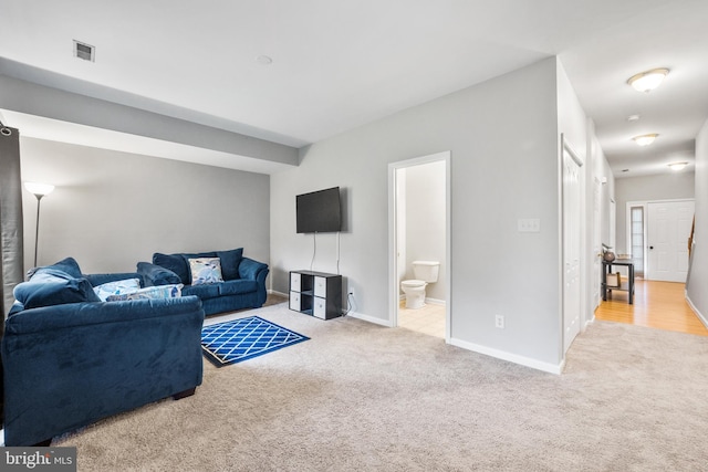 living area with light colored carpet, visible vents, and baseboards