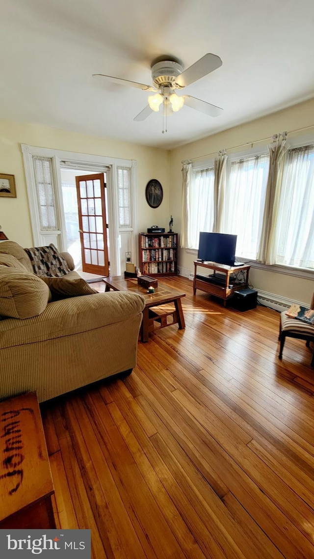 living room with hardwood / wood-style floors, a baseboard radiator, and ceiling fan