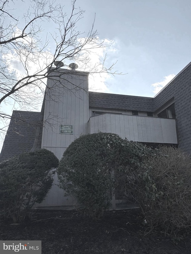 view of side of property featuring a shingled roof