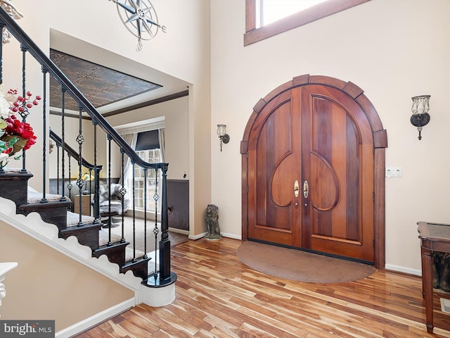 entryway featuring wood finished floors, baseboards, and arched walkways