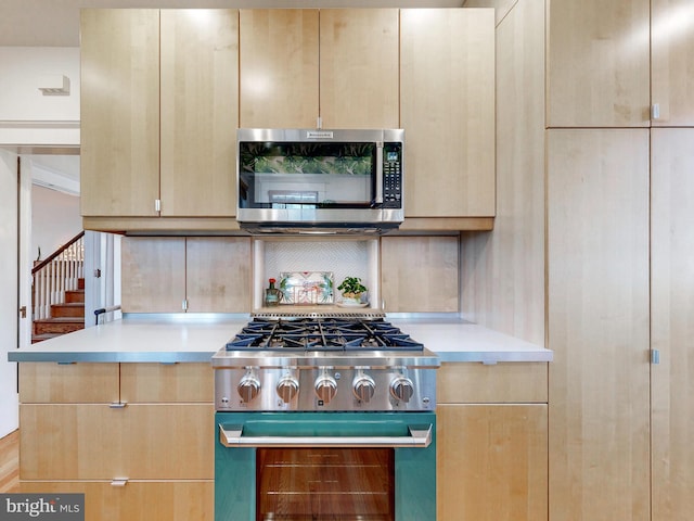 kitchen with light brown cabinetry, tasteful backsplash, and appliances with stainless steel finishes