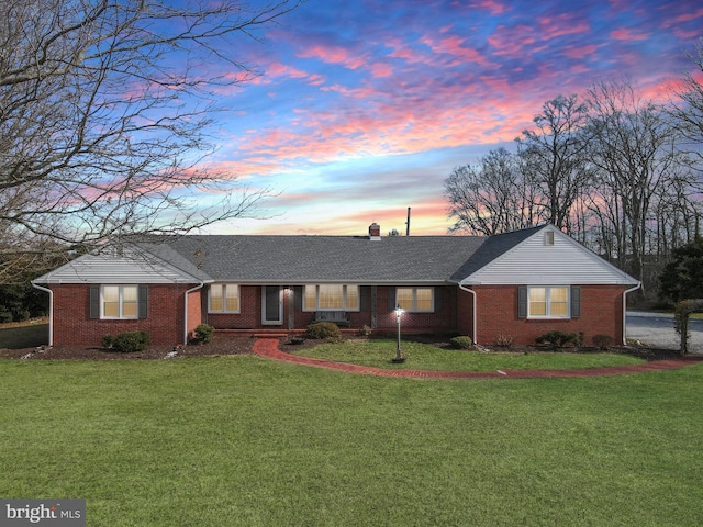 ranch-style home with a yard