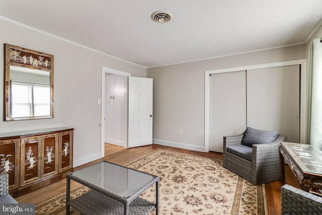 sitting room with hardwood / wood-style flooring and ornamental molding