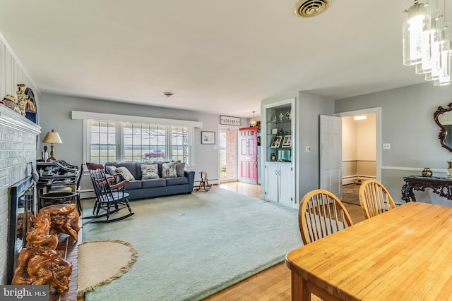 living room with a baseboard radiator, a fireplace, and carpet floors