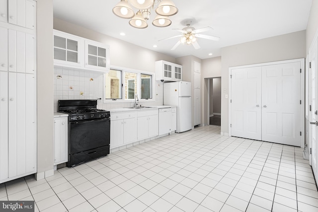 kitchen featuring tasteful backsplash, white cabinetry, sink, and white appliances