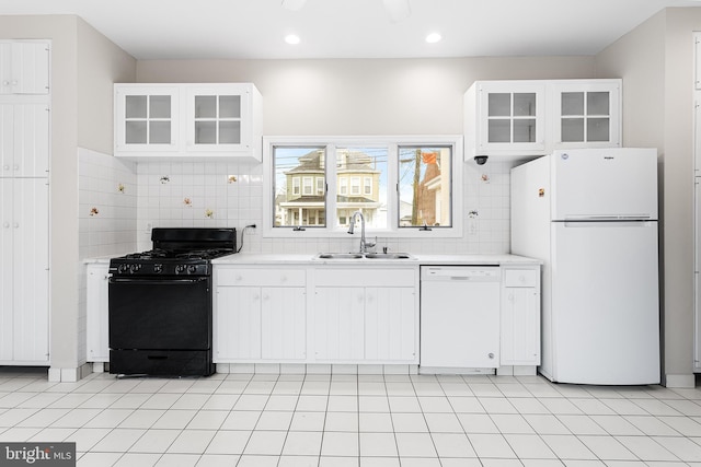 kitchen featuring sink, light tile patterned floors, white cabinets, white appliances, and backsplash