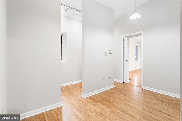 spare room featuring rail lighting and light wood-type flooring