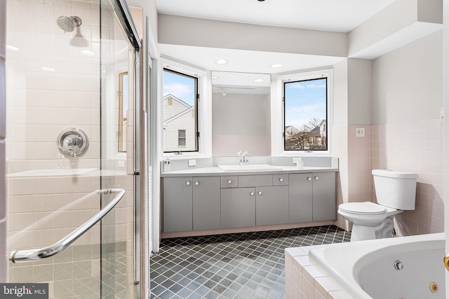 full bathroom featuring tile walls, tile patterned flooring, a healthy amount of sunlight, and separate shower and tub