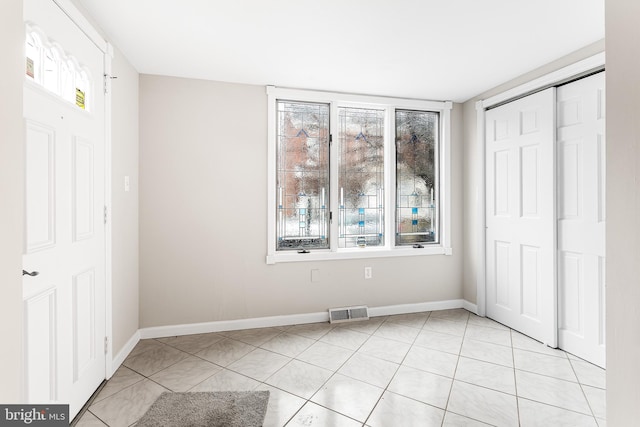 unfurnished bedroom featuring light tile patterned floors and a closet