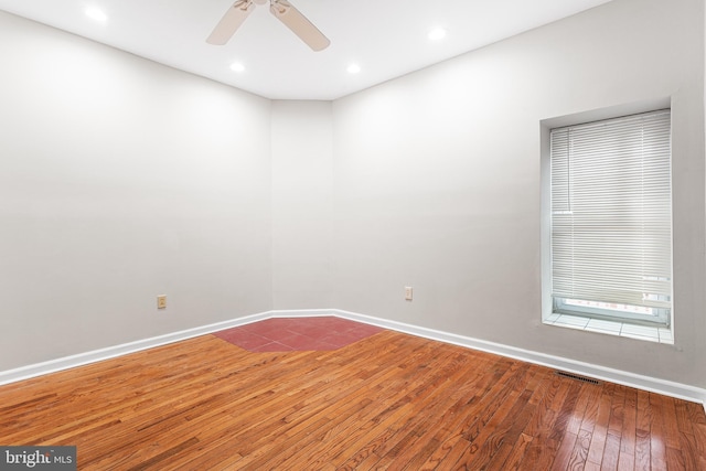 spare room featuring wood-type flooring and ceiling fan