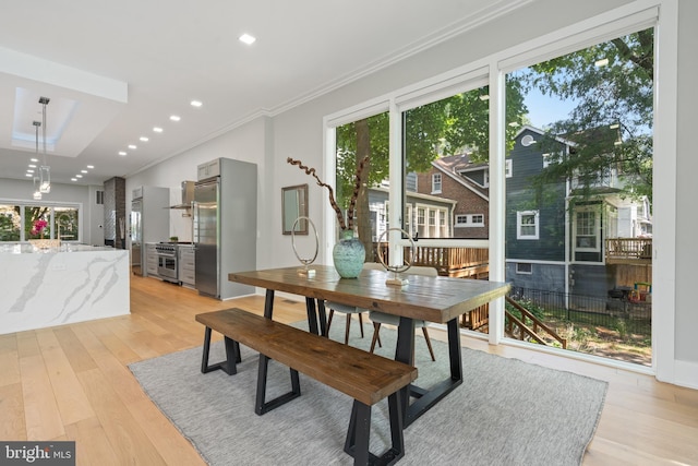 dining room featuring crown molding, light hardwood / wood-style flooring, and plenty of natural light