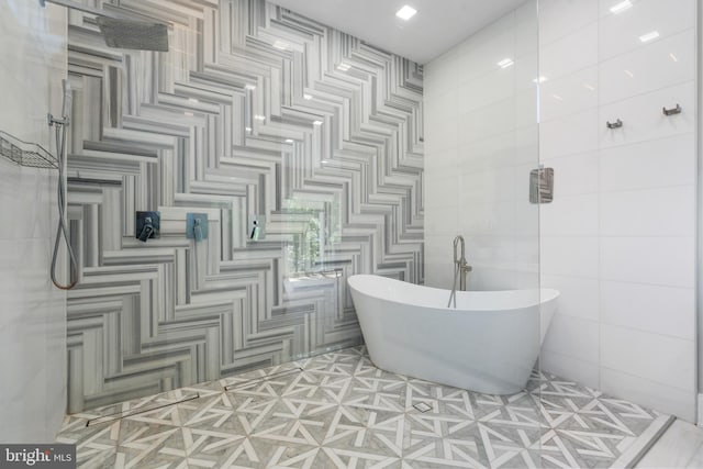 bathroom featuring a bath and tile walls