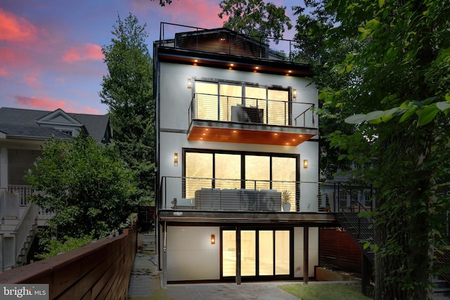 back house at dusk with a balcony