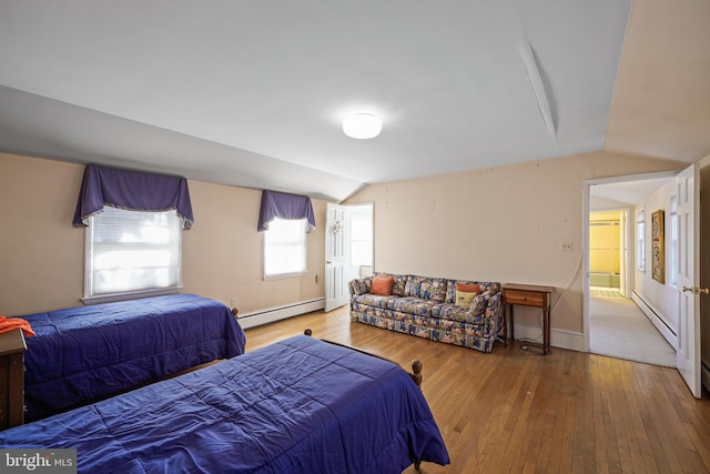 bedroom featuring vaulted ceiling, hardwood / wood-style floors, and baseboard heating