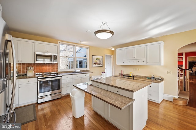 kitchen featuring pendant lighting, appliances with stainless steel finishes, and white cabinets