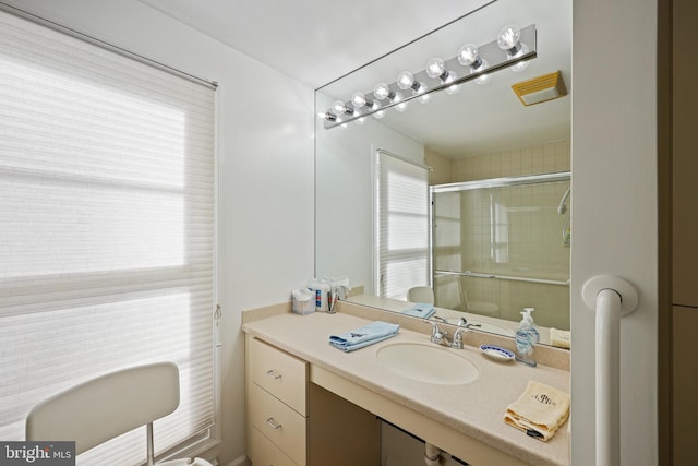 bathroom featuring vanity and a shower with shower door