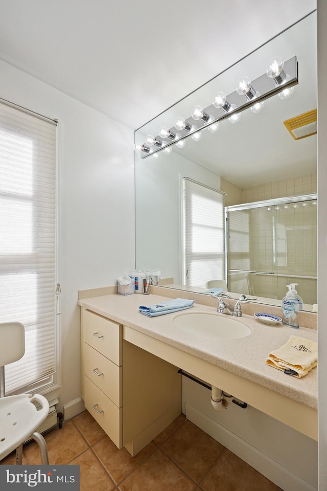 bathroom with an enclosed shower, tile patterned flooring, and sink