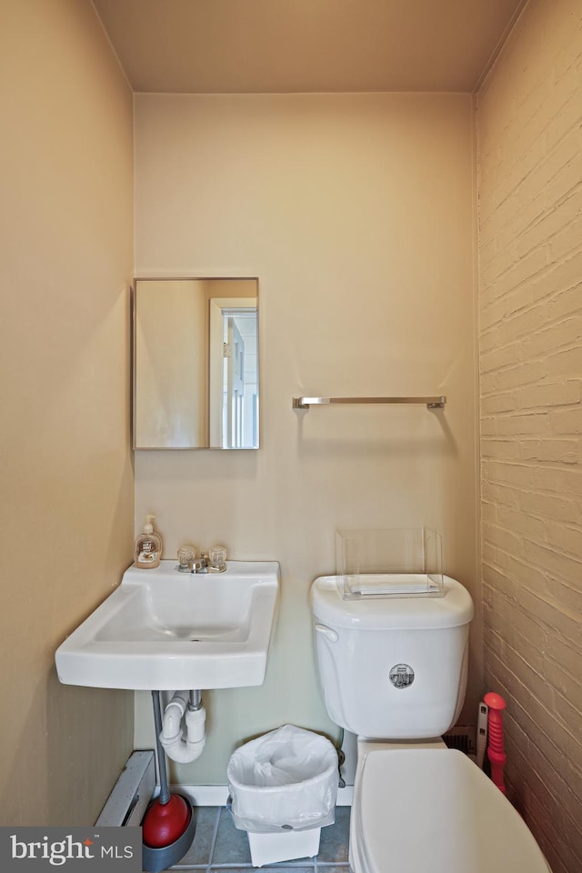 bathroom featuring tile patterned flooring, sink, baseboard heating, and toilet