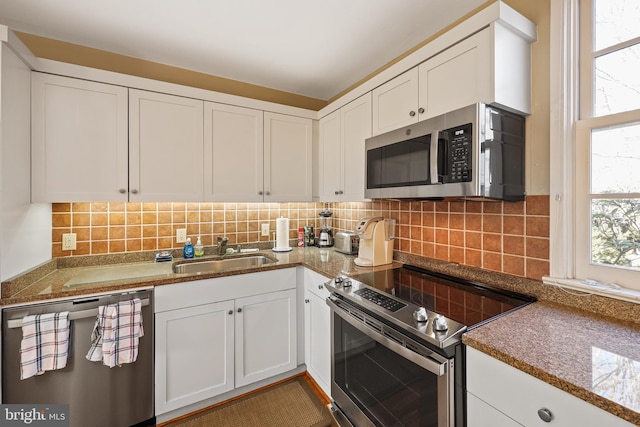 kitchen with stainless steel appliances, sink, white cabinets, and decorative backsplash