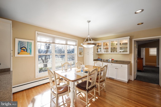 dining room featuring a baseboard radiator and light hardwood / wood-style flooring