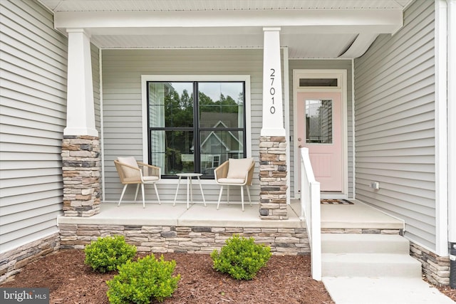 view of exterior entry featuring covered porch